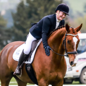 A woman riding a brown horse at an event.
