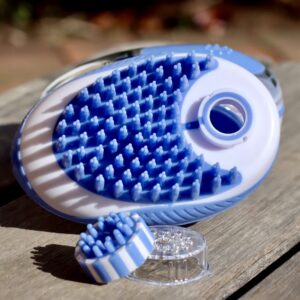A NTR Shampoo Brush on a wooden table.