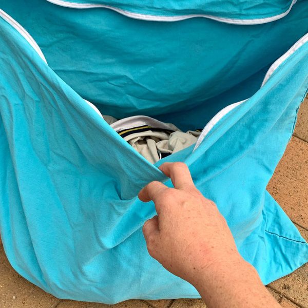 A person opening up an NTR Wash Bag.