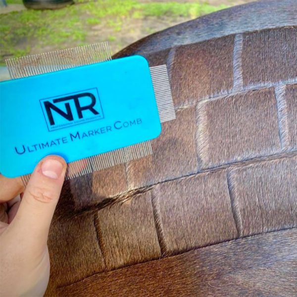 A person holding a blue card with the word NTR on it using an Ultimate Marker Comb.
